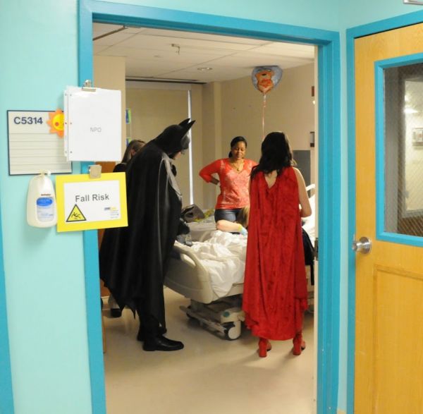 Robinson dressed as Batman, visiting a child in a local hospital